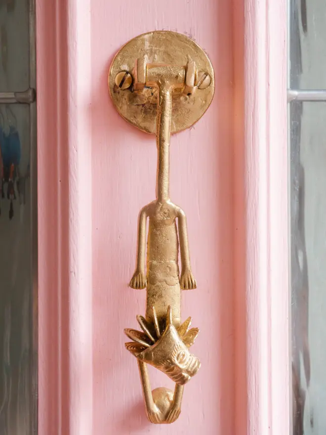 lion door knocker on pink door