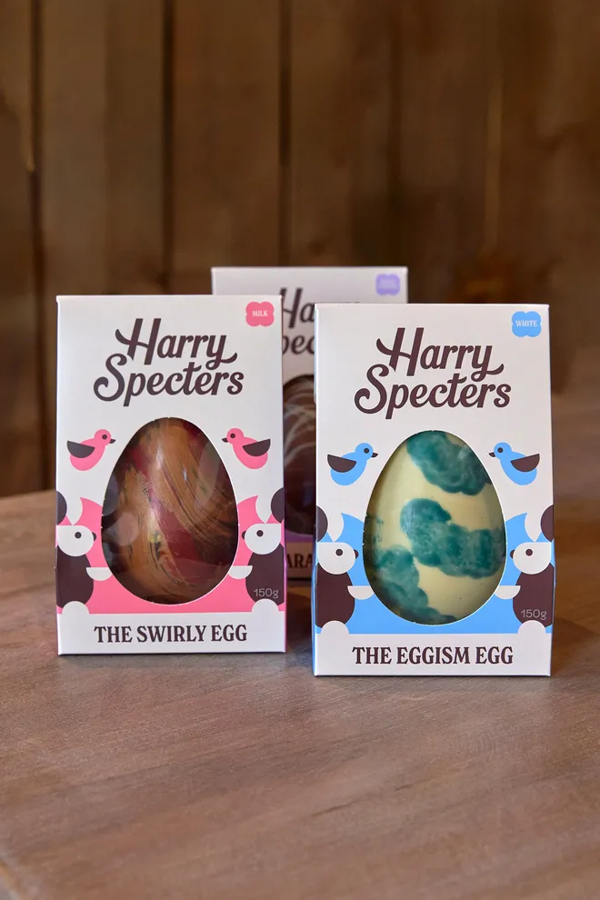 Bundle of three branded eggs on a wooden surface with a wooden panelling wall behind