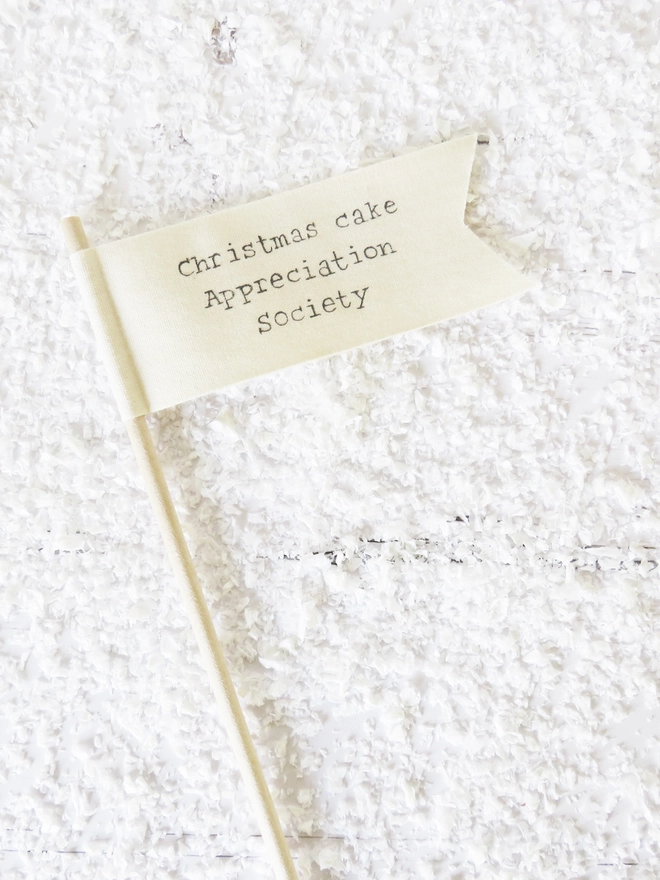 organic cotton flag with hand painted festive message wrapped round wooden dowel.