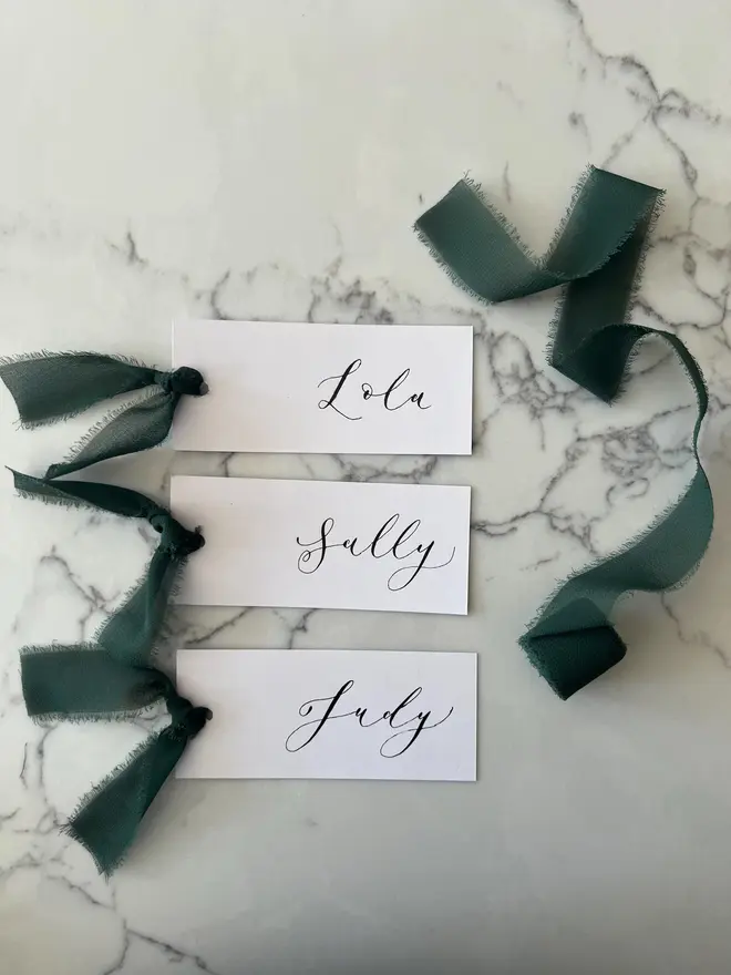 Personalised Calligraphy Wedding White Place Cards, white place cards with forest green ribbon. 
