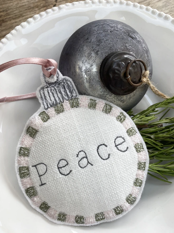 Peace Embroidered Square Edge Detail Bauble in bowl with bauble