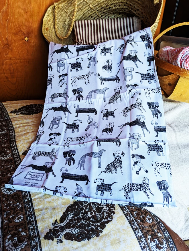 Close up of dogalicious 100% organic cotton charity tea towel with black dog illustrations