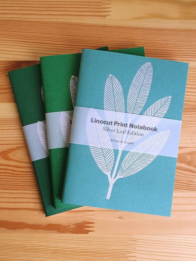 Green notebook with linocut sliver leaf on the cover