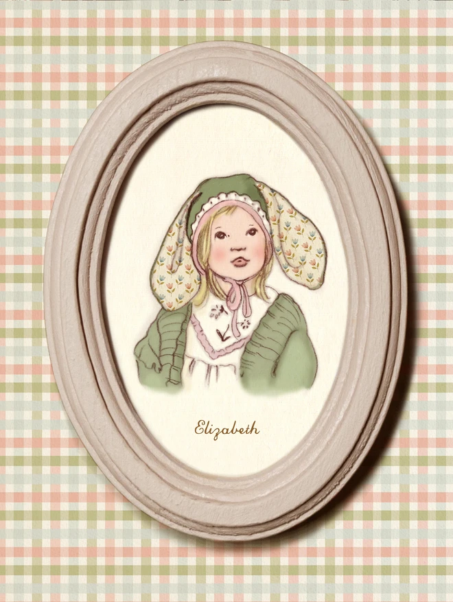 a photograph of a personalised miniature portrait of a little girl in an easter bunny bonnet. Framed in a dusty pink wooden oval frame on an easter gingham back ground 