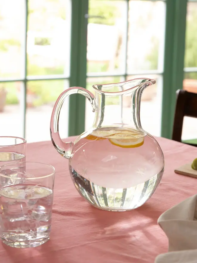 engraved stars crystal water jug. a glass jug patterned with small stars.