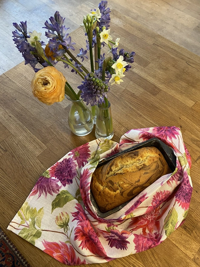 Home made cake wrapped in a pretty pink and white floral linen tea towel