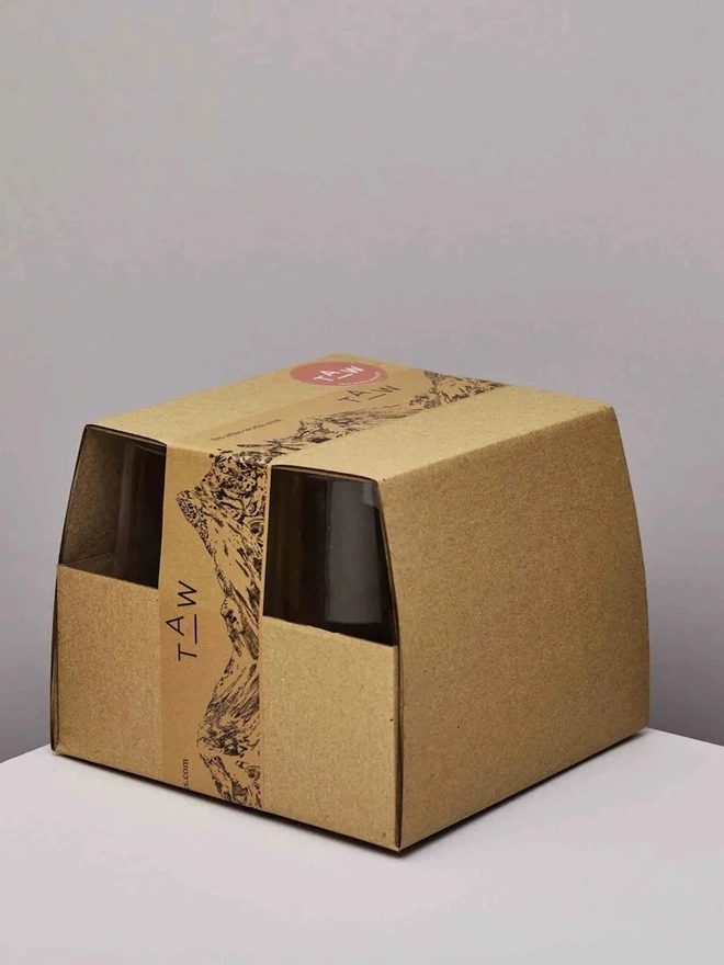 Highball Glasses (Set Of 1 Or 4), a group of highball glasses sitting on a plain counter top against a white backdrop. They are packaged together. 