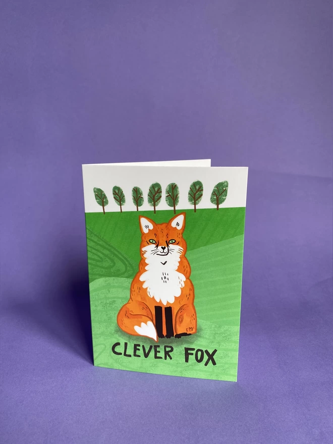 An illustration of an orange and white fox on an A6 Greeting card that reads - Clever Fox