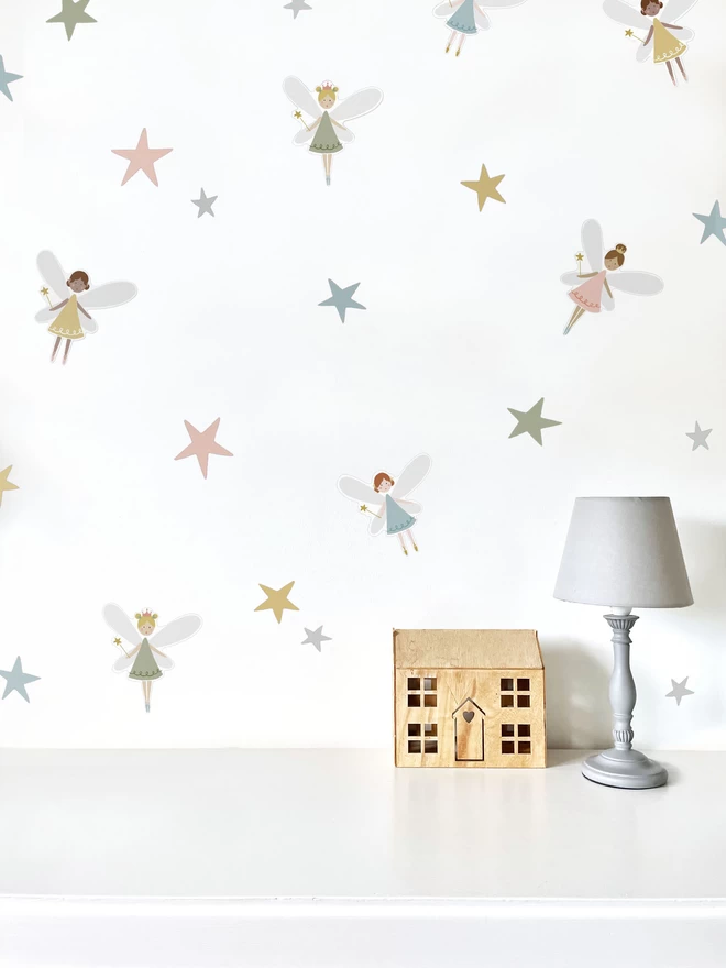 White girls bedroom with fairy wall stickers, lamp and toy house