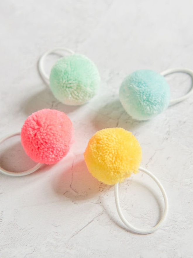 pom pom hair ties (set of four). four pom pom hair ties in pastel colours.