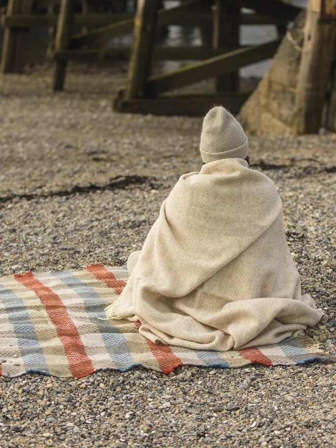 Organic Wool Throw, a person with the wool throw draped over them. 