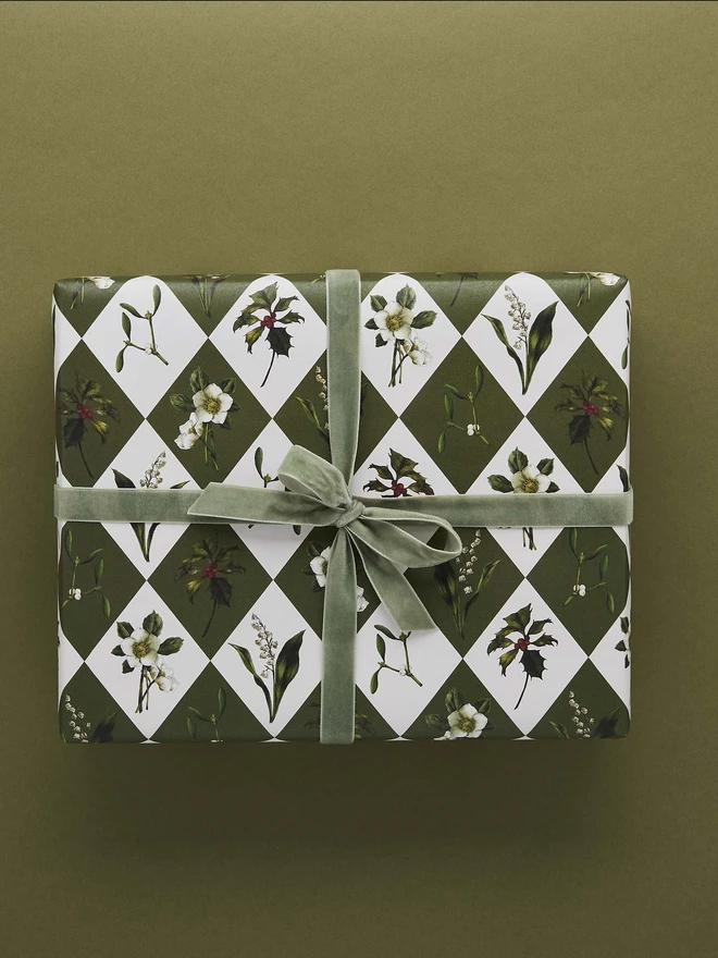 green and ivory harlequin pattern with festive botanicals wrapping paper