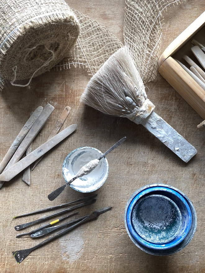 Modelling tools and plaster tools and materials on a wooden bench