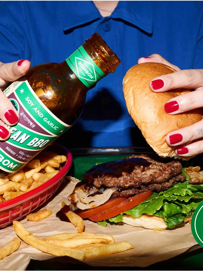 soy and garlic korean bbq sauce. a close up of korean bbq sauce being poured onto a burger.