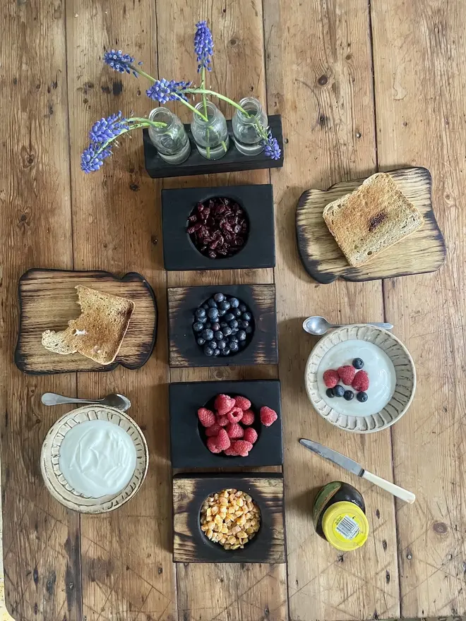 Charred nibble bowls with fruit and two small toast boards