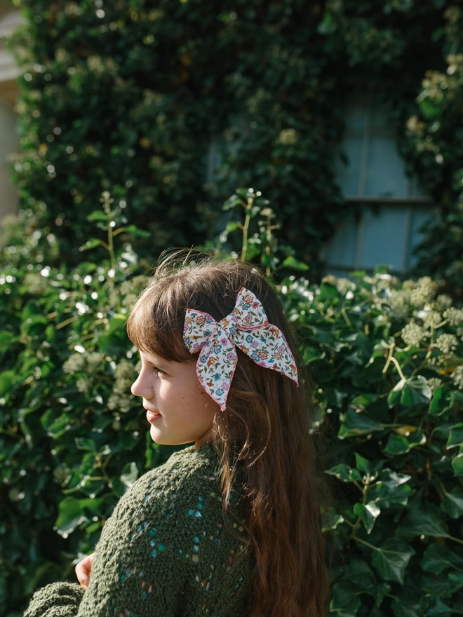 girl outside with liberty bow in the side of her hair 