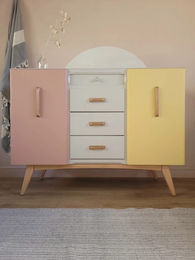 Mid-century sideboard painted in pink, yellow and putty colours