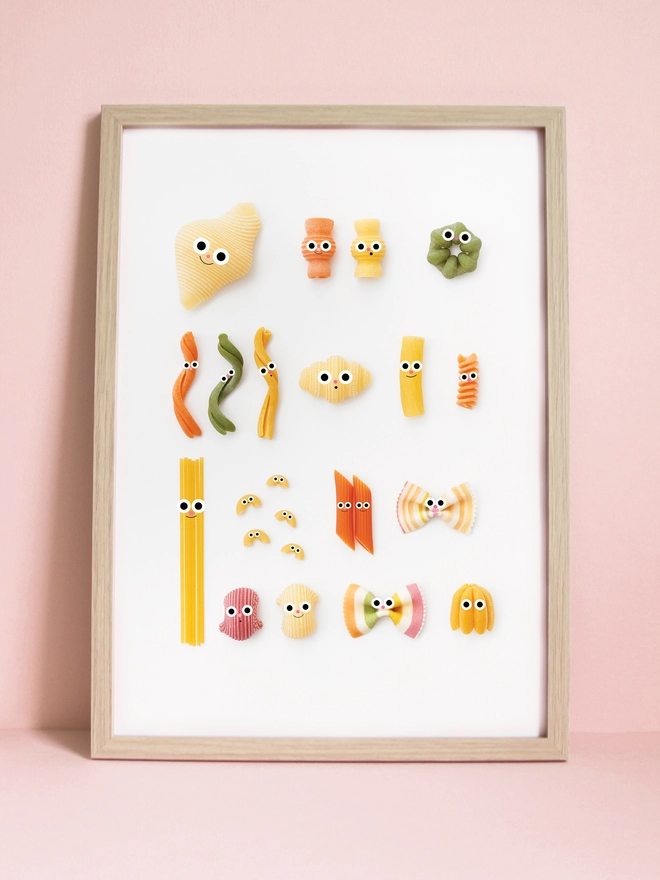 An A3 print of a collection of pasta, each with little faces.  on a white background 