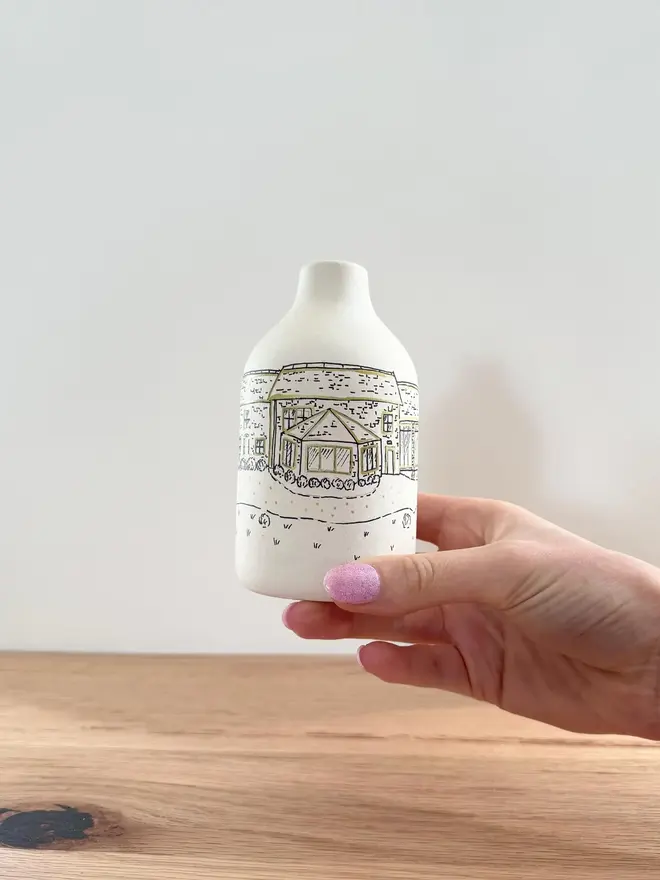 A womans hand holding a custom Wedding Venue Hand Drawn Vase 