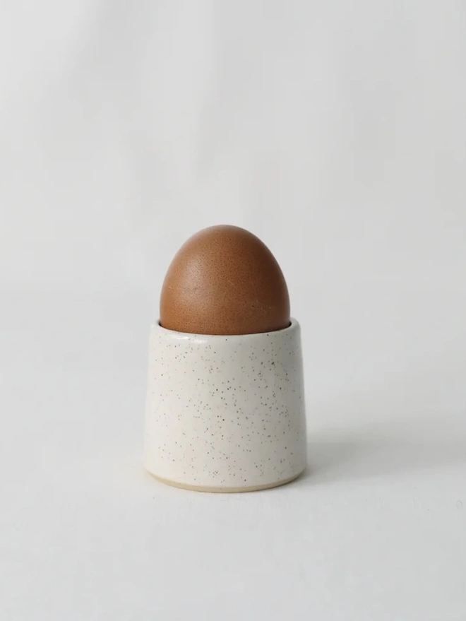 Classic Handmade Egg Cup, a ceramic egg cup sitting on a plain surface against a white backdrop. 