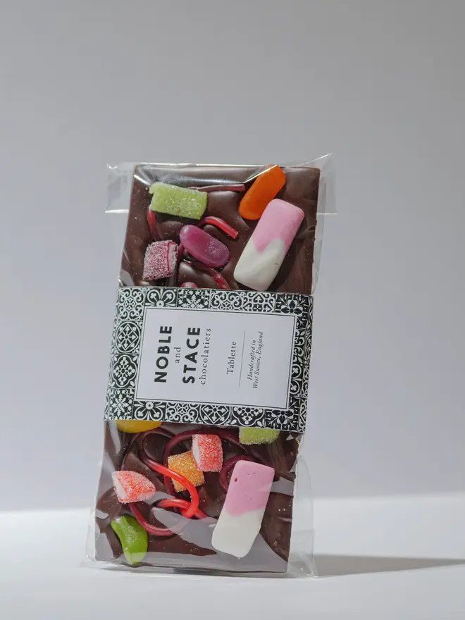 Rainbow sweet chocolate tablette wrapped and standing on a white table. 