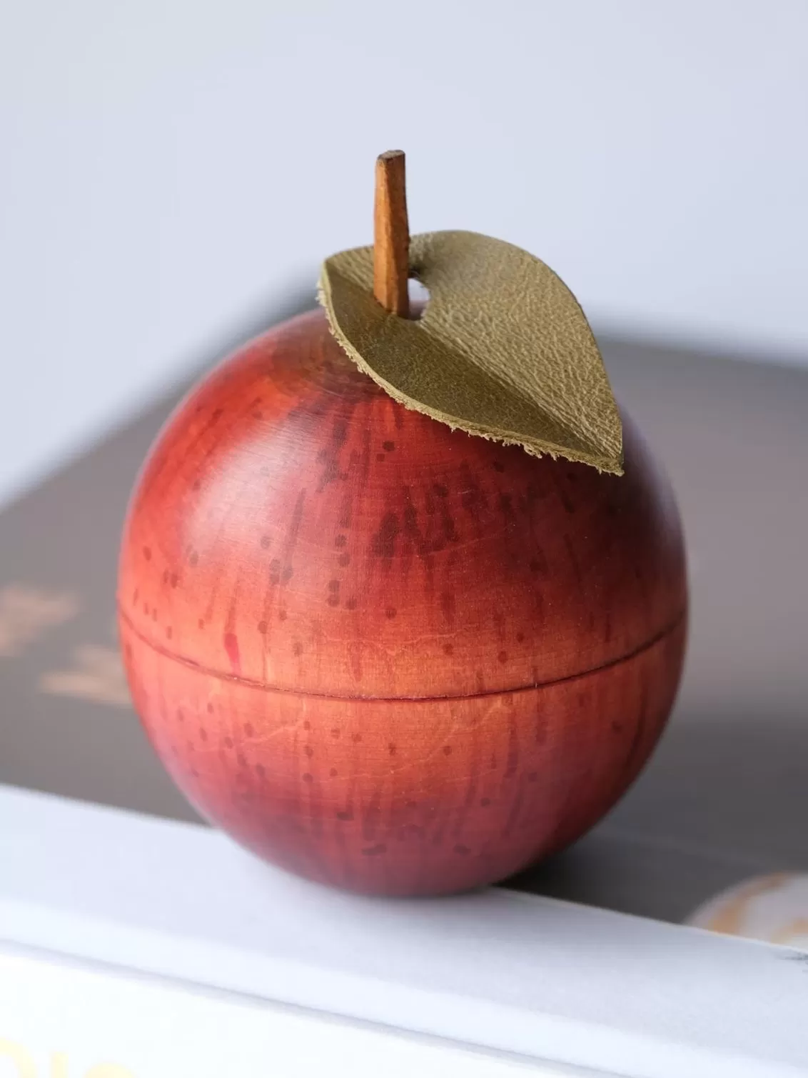 Wooden apple ornament placed on a book