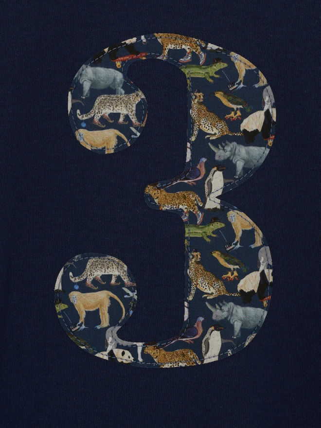 a close up of a number 3 birthday t-shirt with a zoo animal liberty print 3 appliqué 