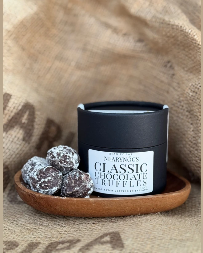 Chocolate Truffles, a tub of chocolates sitting on a sack backdrop accompanied by chocolate truffles. 