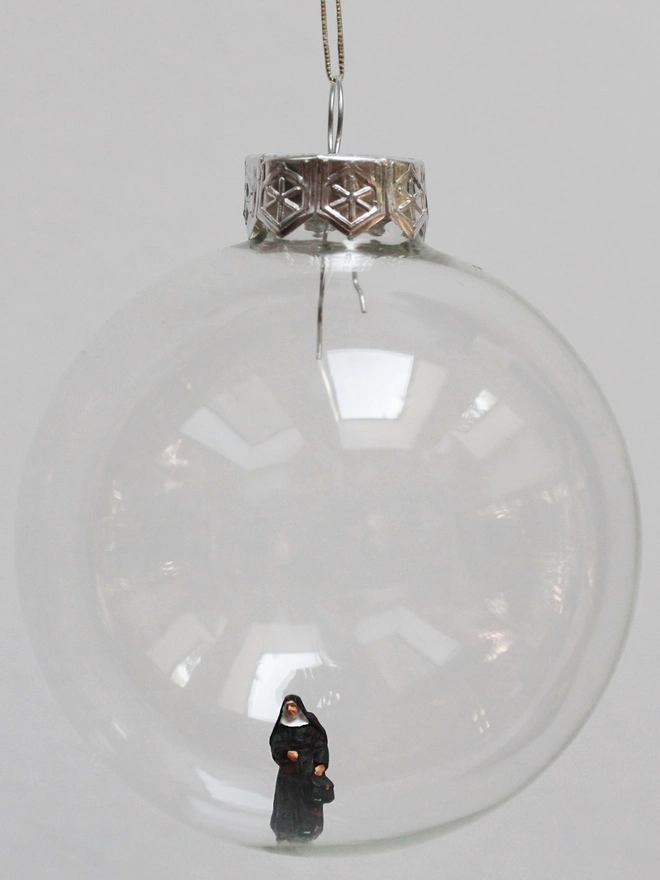 Miniature figure of a nun in a glass Christmas bauble 