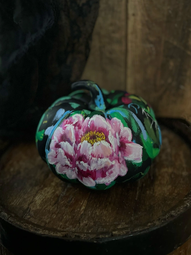 Unique hand-painted ceramic pumpkin black background with vibrant bold pink peony flowers.
