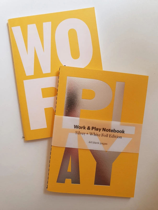 Yellow notebook with the words work and play on the cover