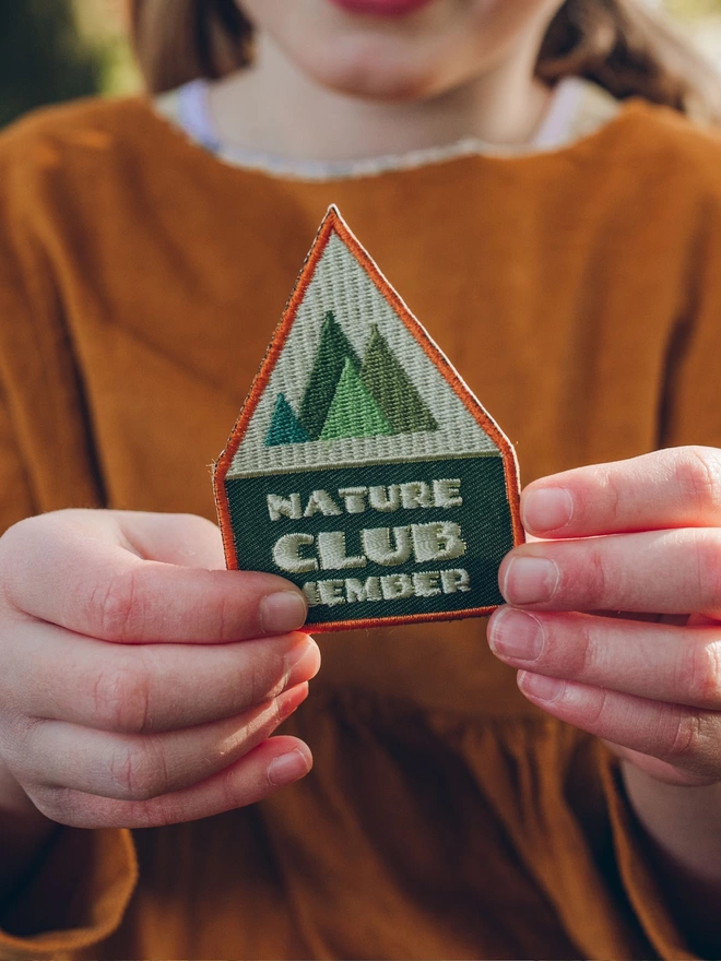 Girl holding Nature Club Member embroidered patch