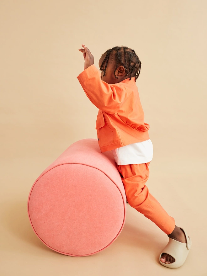 toddler in a cool jacket for girls and boys unisex in bright orange. made in the uk by studio koter and worn with matching orange oversize trousers