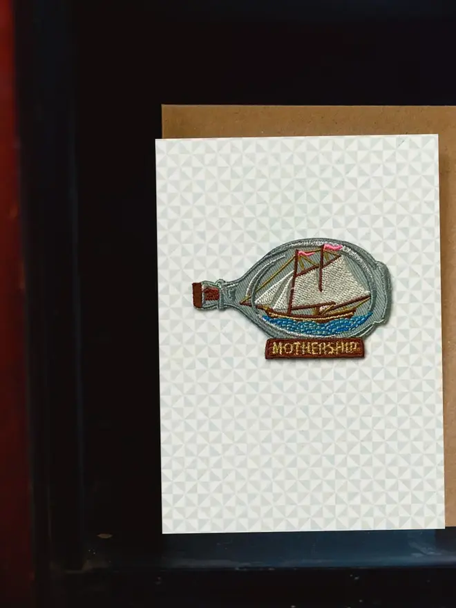 Mothership Embroidered Iron On Patch Mothers Day card on a shelf