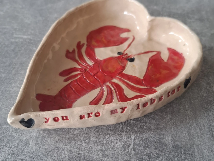 handmade you are my lobster ceramic heart shaped bowl showing the side of the bowl with the words 'you are my lobster' stamped into it