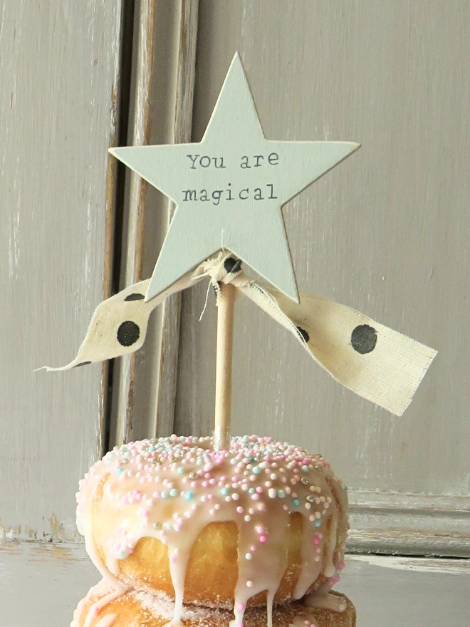 wooden star shaped cake topper with hand painted message and ribbon detail