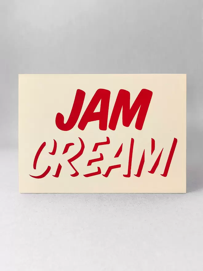 Cream at the bottom, Jam on top, printed in red ink on this cream card. Stood in a light grey studio with soft shadows.