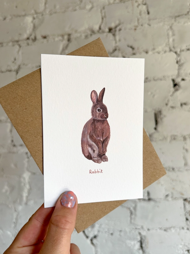 A greetings card featuring an illustrated rabbit with a brown kraft envelope