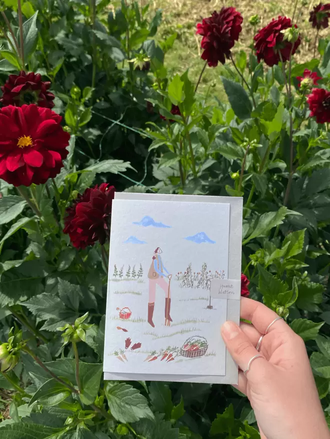 greetings card in front of dahlias growing. 
