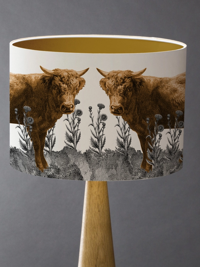 Lampshade of Highland cows in a field of Scottish thistles