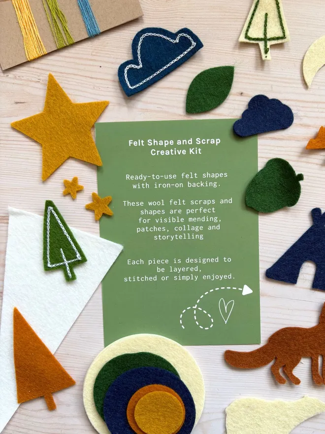Felt shapes and scraps laid out with an instruction card on a wooden backround