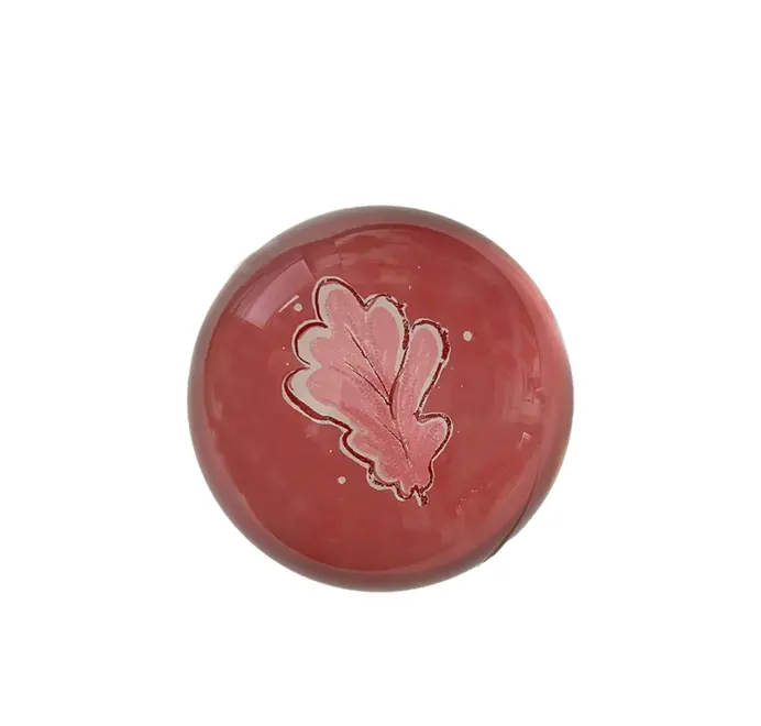 Round pink oak leafpaper weights on a white background. 