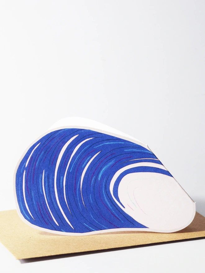 A cut out card of a mussel sitting on top of an envelope