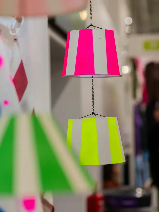 Hand Painted Upcycled Striped Sustainable Drum Lampshade, colourful lampshades hanging in a studio from a string. 