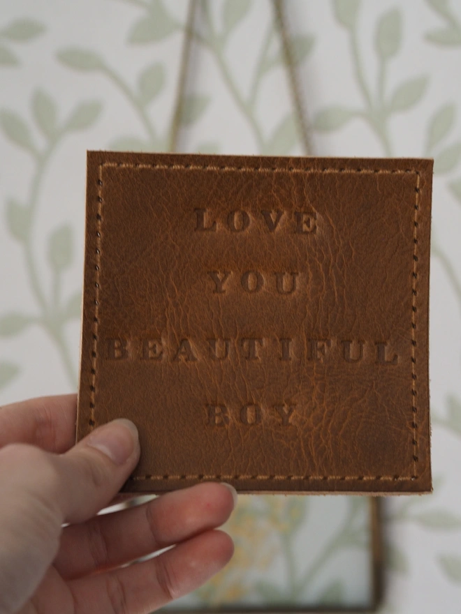 Personalised leather coaster. Hand dyed tan brown leather square coaster personalised with a short but sweet message.
