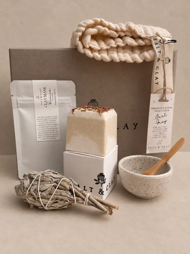 a relaxing box of bath and body products in a grey card box with a fizzing bath bomb.