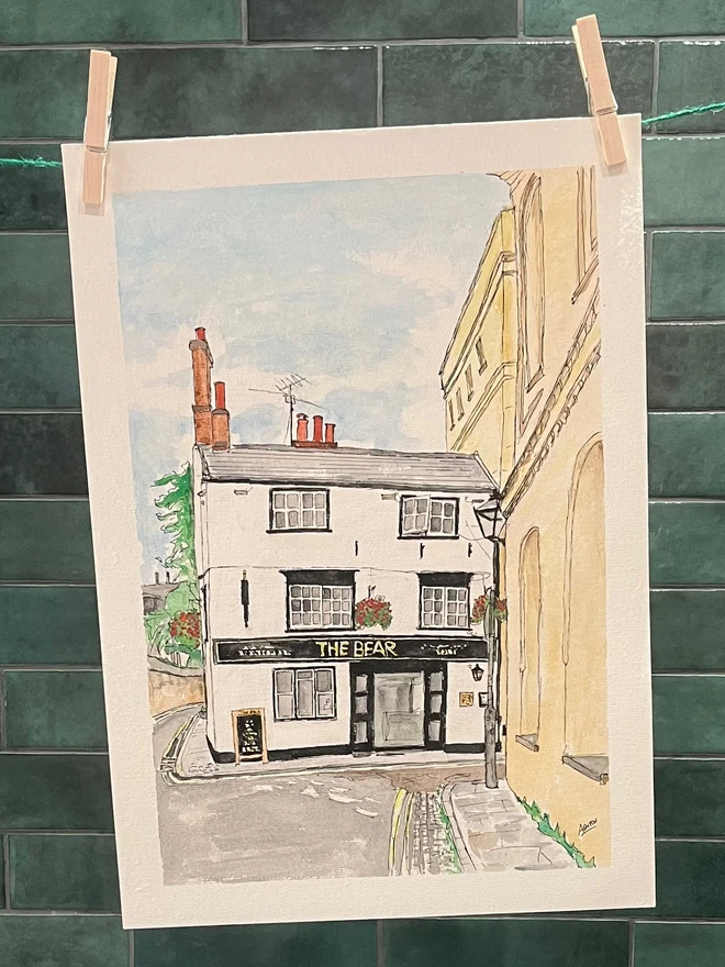 watercolour painting of a Pub, hanging from a clothesline in front of green tile