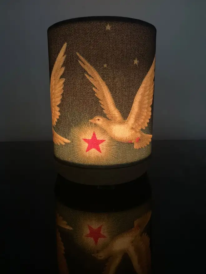 Dove candle holder shade glowing with a lit tealight