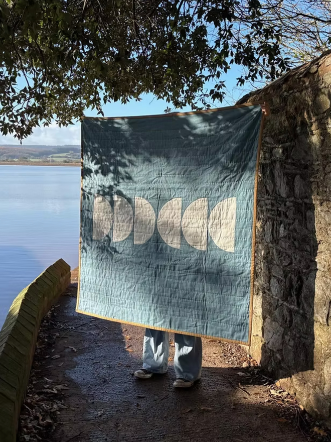 Wax & Wane Reversible Linen Throw Quilt. A blue and white quilt.