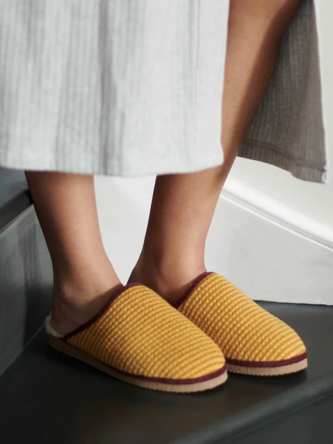 Women's Lambswool & Sheepskin Slippers, a person wearing a pair of colourful slippers indoors. 
